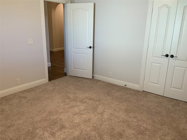 unfurnished bedroom with carpet flooring and a closet