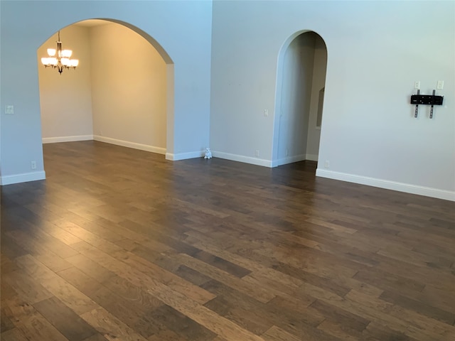 unfurnished room with dark hardwood / wood-style flooring and an inviting chandelier