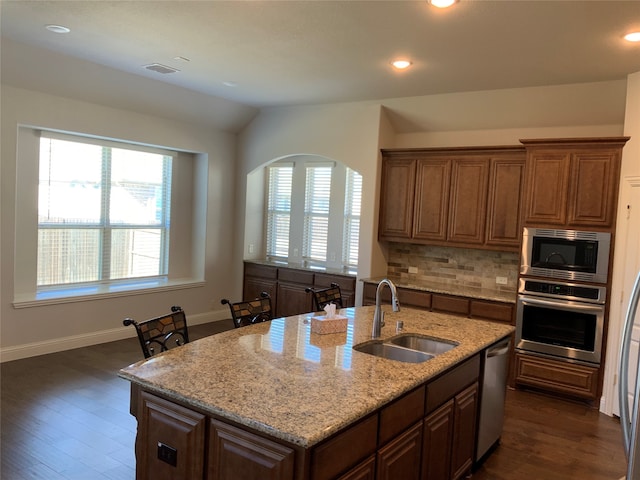 kitchen with plenty of natural light, sink, appliances with stainless steel finishes, and an island with sink