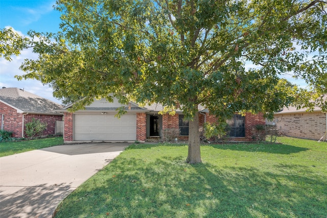 view of property hidden behind natural elements featuring a front lawn and a garage