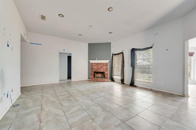 unfurnished living room featuring a fireplace and light tile patterned floors