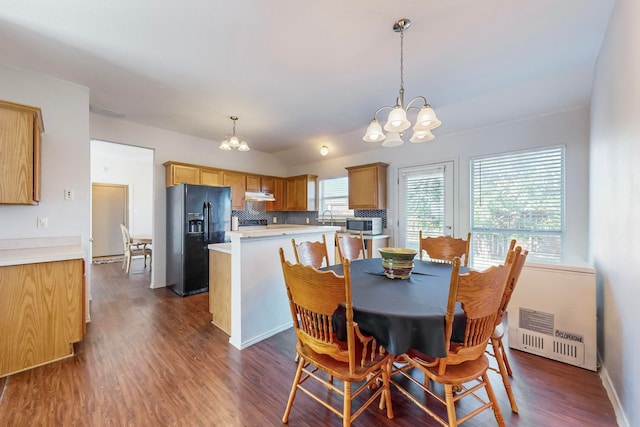 dining space with dark hardwood / wood-style flooring, a chandelier, and sink