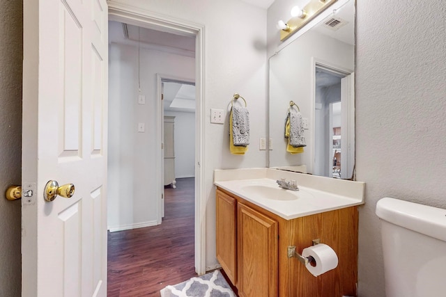 bathroom featuring hardwood / wood-style floors, vanity, and toilet