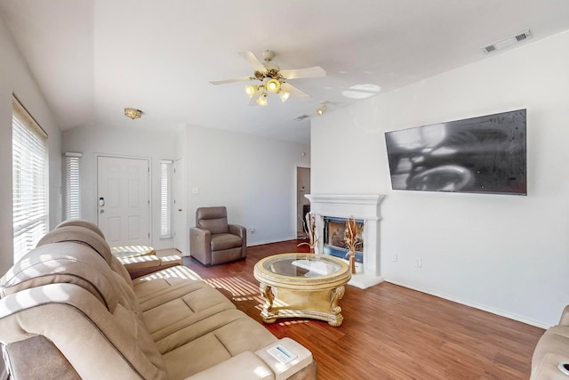 living room with ceiling fan, lofted ceiling, and hardwood / wood-style flooring