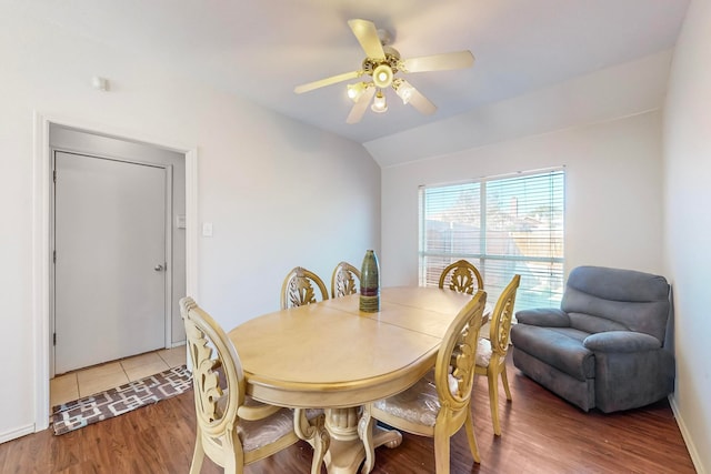 dining room with ceiling fan, hardwood / wood-style floors, and vaulted ceiling