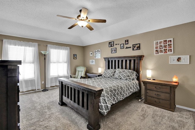 bedroom featuring ceiling fan, light colored carpet, and a textured ceiling