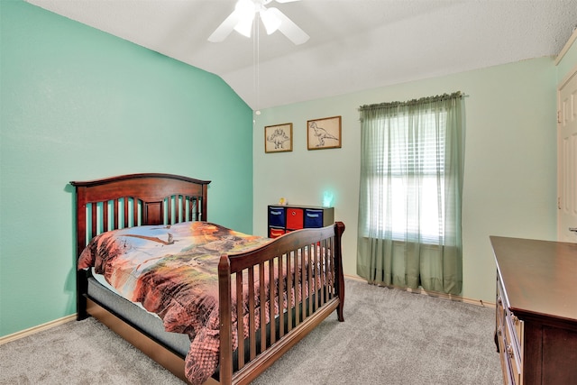 carpeted bedroom with ceiling fan and vaulted ceiling