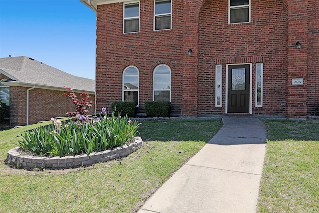 view of exterior entry with a yard