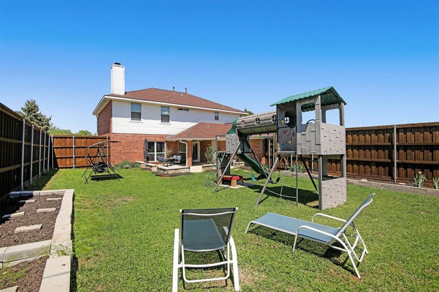 back of house featuring a lawn and a playground