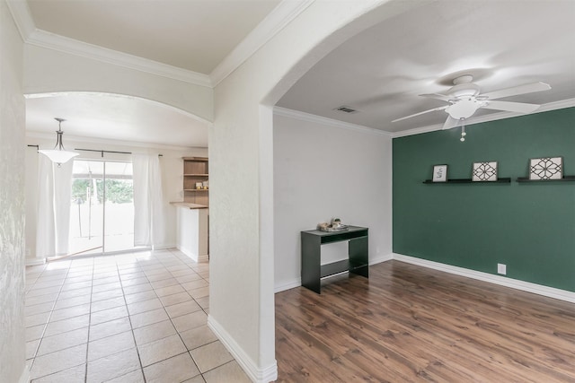 unfurnished room with crown molding, hardwood / wood-style floors, and ceiling fan