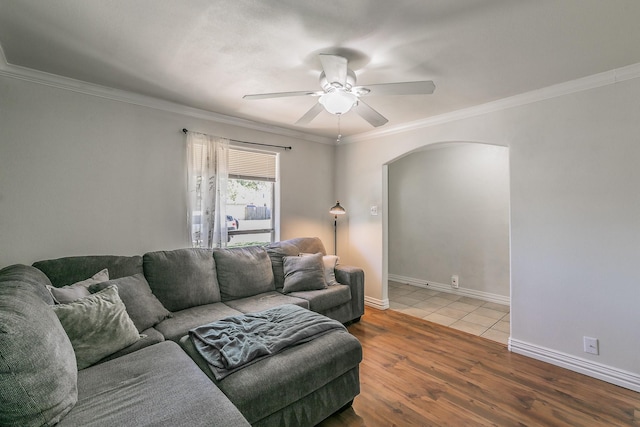 living room with hardwood / wood-style flooring, ceiling fan, and crown molding