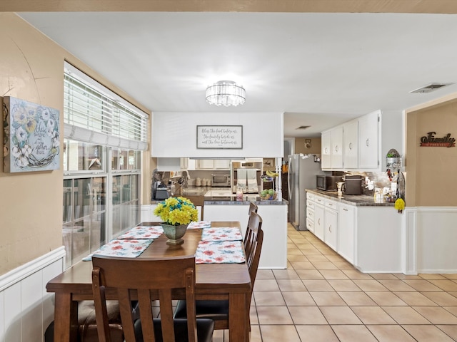 dining room with light tile patterned flooring, an inviting chandelier, and sink