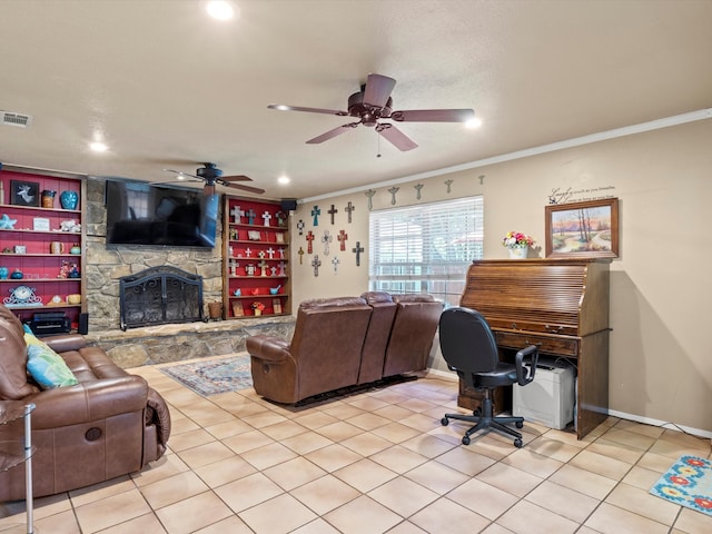 tiled living room featuring ceiling fan, a stone fireplace, and crown molding