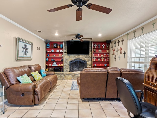 living room with a stone fireplace, crown molding, light tile patterned floors, and ceiling fan