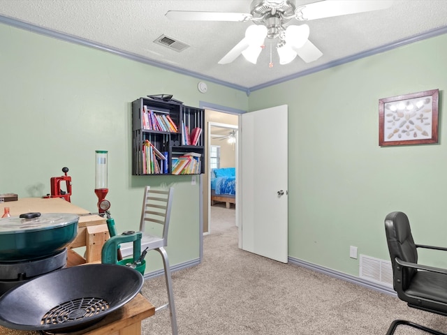 home office featuring ceiling fan, crown molding, light colored carpet, and a textured ceiling