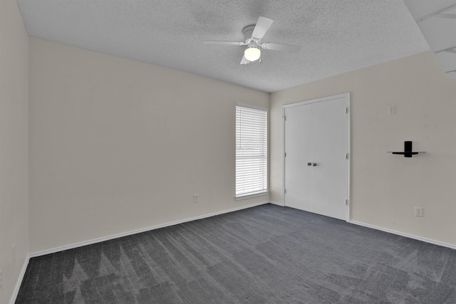 carpeted spare room with ceiling fan and a textured ceiling