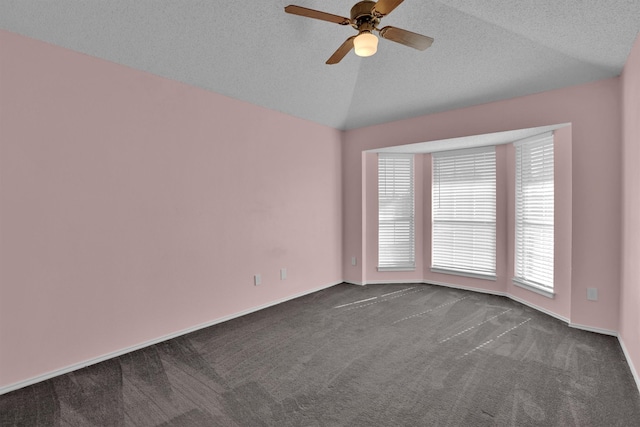 carpeted empty room with a textured ceiling, vaulted ceiling, and ceiling fan