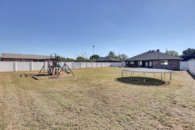 view of yard with a playground and a trampoline