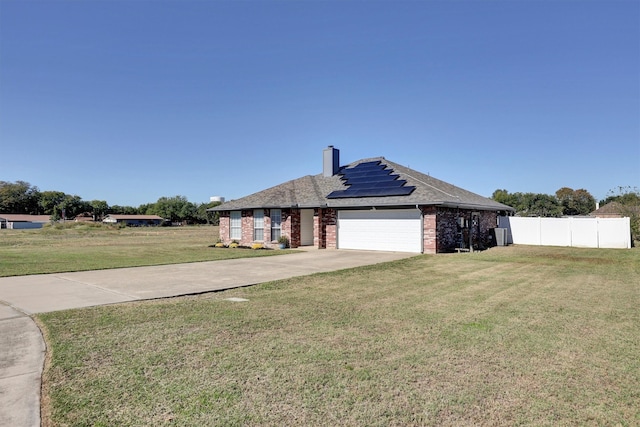 view of front of house with solar panels, a garage, and a front lawn