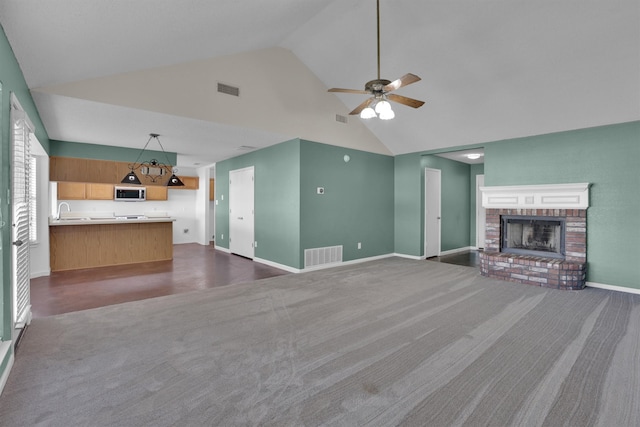 unfurnished living room featuring a fireplace, dark colored carpet, high vaulted ceiling, and ceiling fan