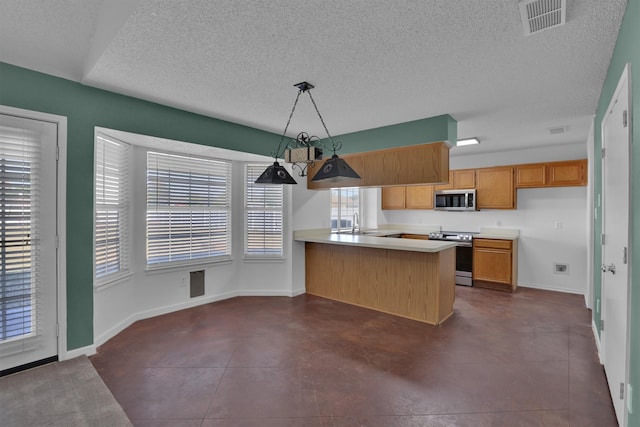 kitchen with pendant lighting, sink, a textured ceiling, kitchen peninsula, and stainless steel appliances