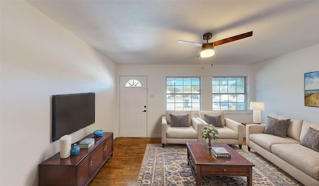 living room featuring ceiling fan and dark wood-type flooring