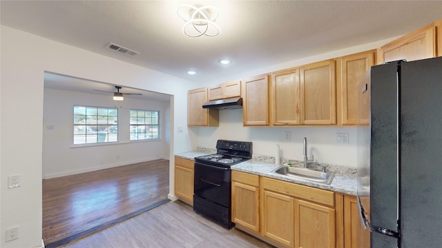 kitchen featuring light brown cabinetry, sink, black appliances, and light hardwood / wood-style floors