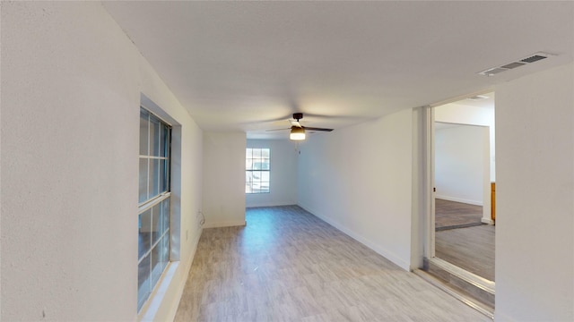 empty room with ceiling fan and light wood-type flooring