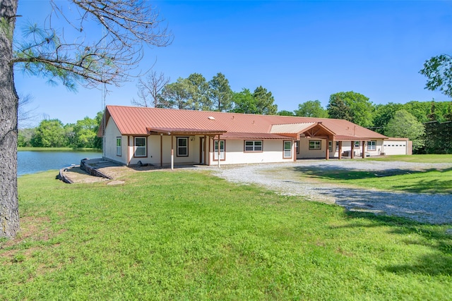 single story home with a water view, a front yard, and a garage