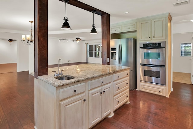 kitchen featuring dark wood-type flooring, sink, light stone countertops, decorative light fixtures, and stainless steel appliances