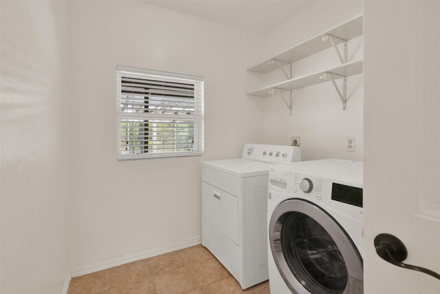 laundry room with washer and clothes dryer and light tile patterned flooring