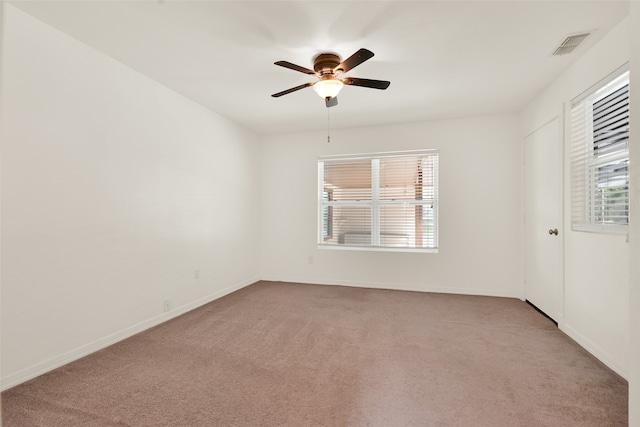 carpeted empty room with plenty of natural light and ceiling fan