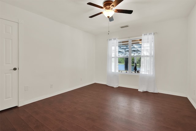 empty room featuring ceiling fan and dark wood-type flooring