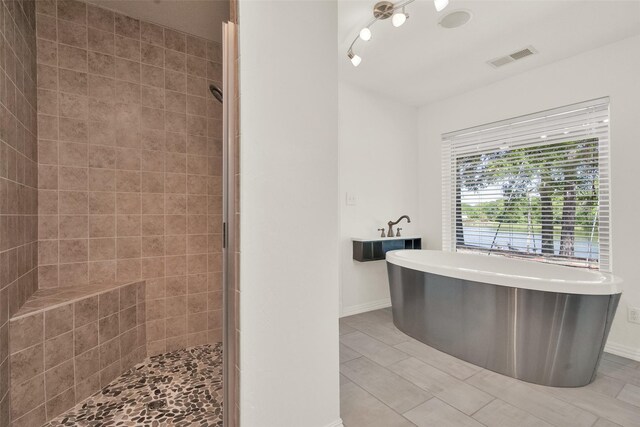 bathroom featuring tile patterned floors and independent shower and bath