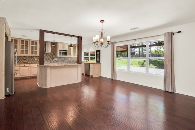 kitchen with a center island, hanging light fixtures, stainless steel appliances, dark hardwood / wood-style floors, and cream cabinets