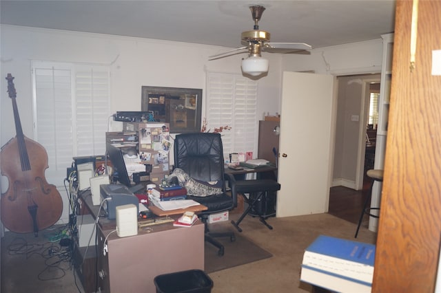 carpeted office space featuring ceiling fan and crown molding