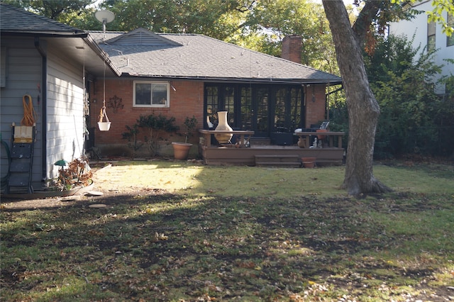 rear view of house featuring a lawn and a wooden deck