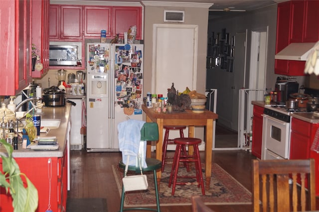 kitchen with crown molding, dark hardwood / wood-style flooring, white appliances, and sink