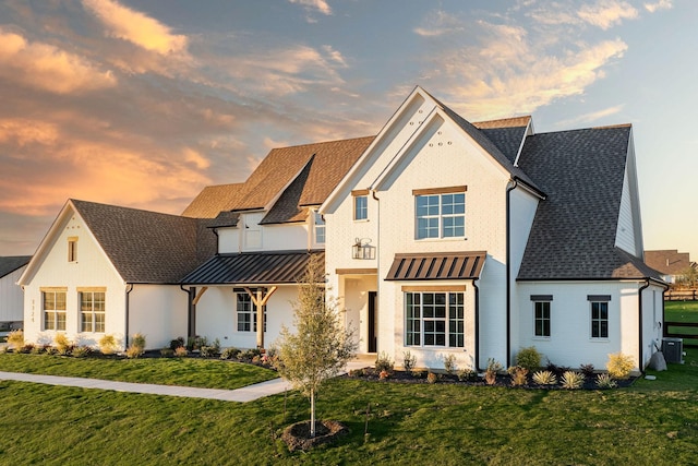 view of front of house featuring a yard and central AC unit