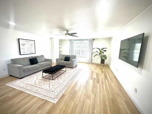 living room with light hardwood / wood-style flooring, ceiling fan, built in features, ornamental molding, and a textured ceiling