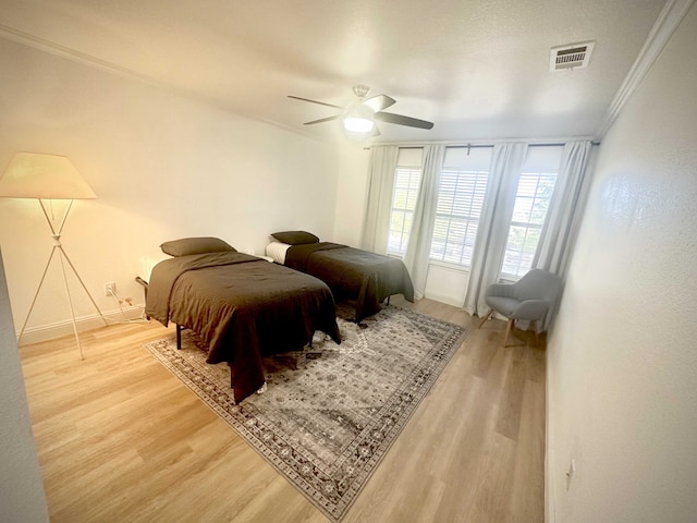 bedroom featuring wood-type flooring, ceiling fan, and ornamental molding