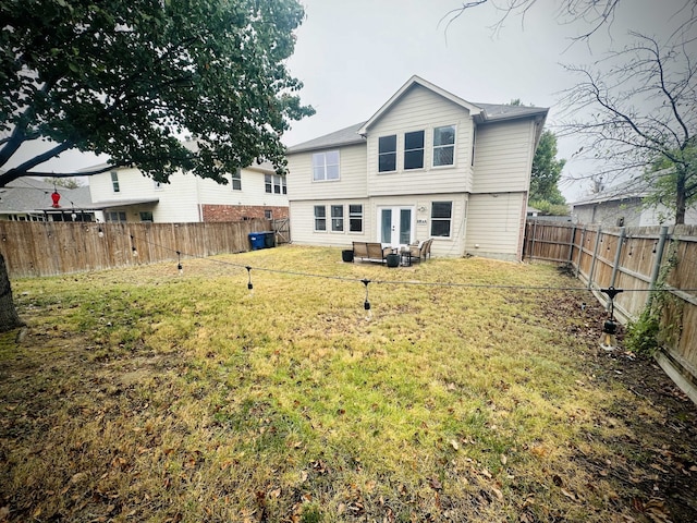 back of property featuring french doors and a lawn