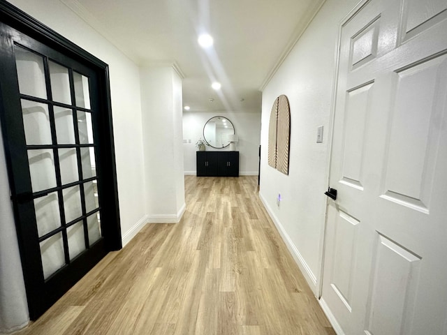 corridor featuring crown molding and light hardwood / wood-style flooring