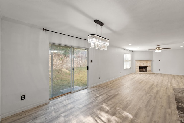 unfurnished living room featuring a fireplace, light hardwood / wood-style flooring, and ceiling fan