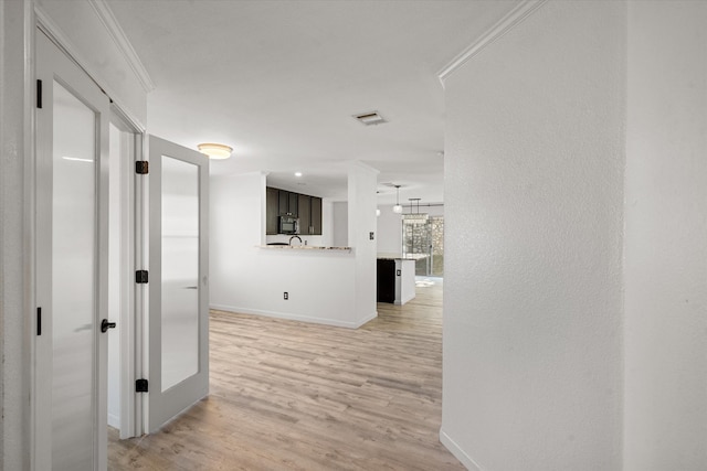 kitchen with sink, electric range oven, light hardwood / wood-style floors, pendant lighting, and dark brown cabinets