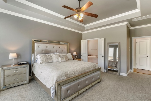 bedroom with light carpet, a tray ceiling, visible vents, and baseboards