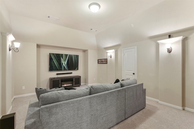 living area featuring a glass covered fireplace, visible vents, light carpet, and baseboards