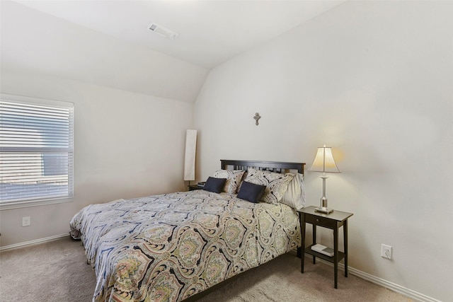 carpeted bedroom featuring lofted ceiling, visible vents, and baseboards