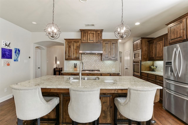 kitchen featuring a large island, visible vents, hanging light fixtures, appliances with stainless steel finishes, and extractor fan