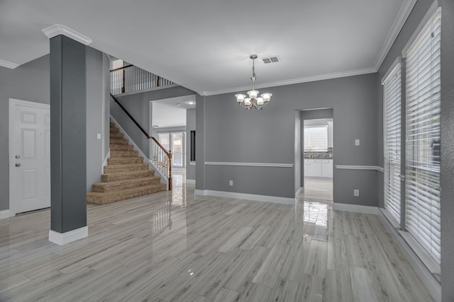 spare room with a chandelier, crown molding, and light hardwood / wood-style flooring